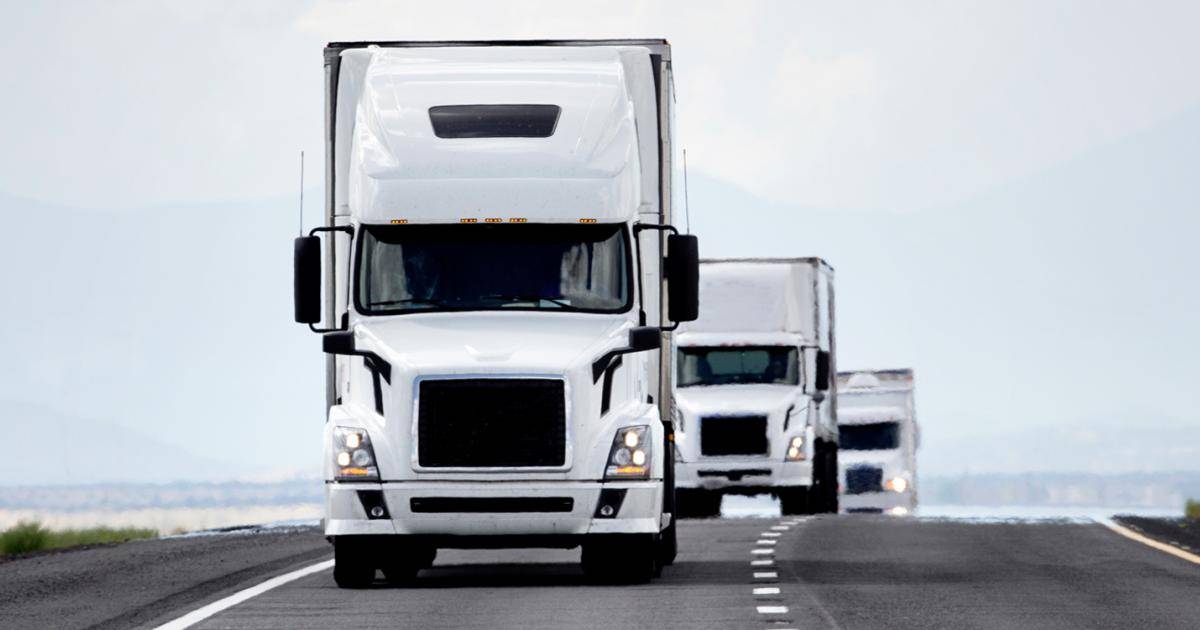 White trucks driving on the freeway.